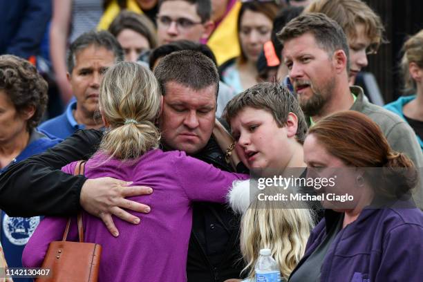Police officer hugs his family after they were evacuated to the Recreation Center at Northridge after at least seven students were injured during a...