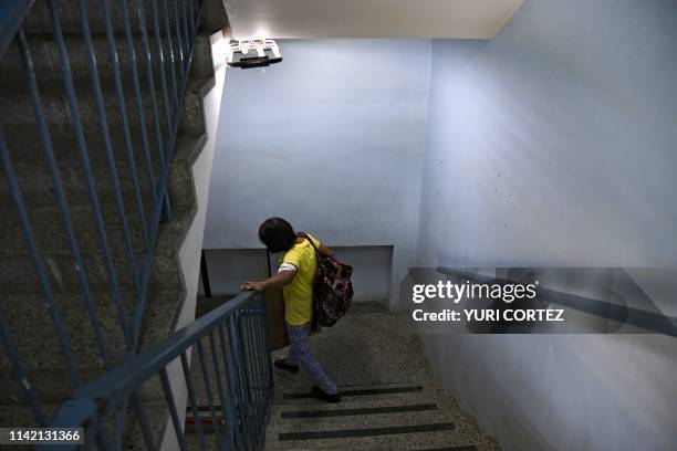 Patient suffering from renal failure walks downs the stairs after receiving hemodialysis treatment at a clinic in Barquisimeto, Venezuela, on April...