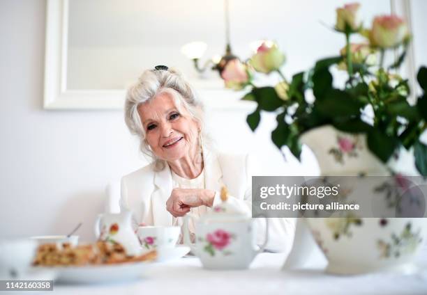 April 2019, Berlin: EXCLUSIVE - Helga Piur, actress, sits at a laid table in the dining room. Photo: Britta Pedersen/dpa-Zentralbild/ZB