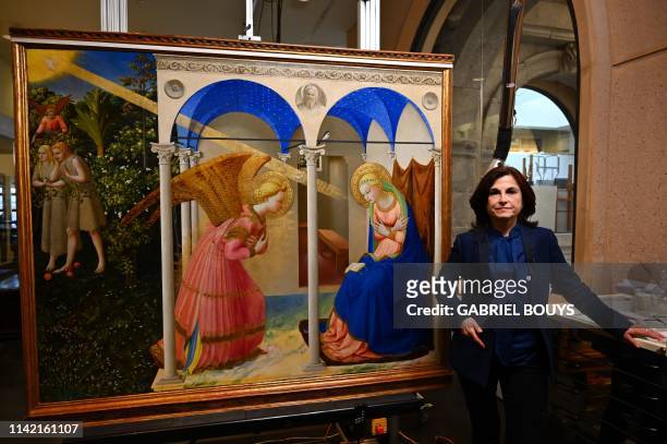Almudena Sanchez, restorer of Spanish 'Museo del Prado', poses next to "The Annunciation" retable by Italian painter Fra Angelico following a press...