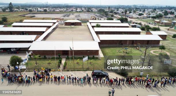 People queue outside Marikana Primary School to cast their votes during South Africa's national and provincial elections on May 8, 2019. South...