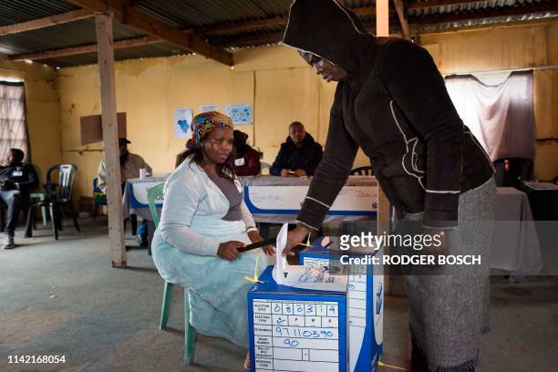 People vote in a large shack being used as a voting station in an impoverished area in Khayelitsha on May 8, 2019 in Cape Town during South Africa's...