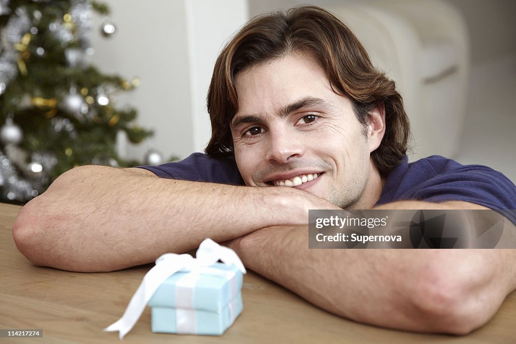 Man leaning on table in front of small gift box, Cape Town, Western Cape Province, South Africa