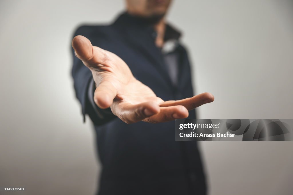 Midsection Of Man Reaching Against Gray Background