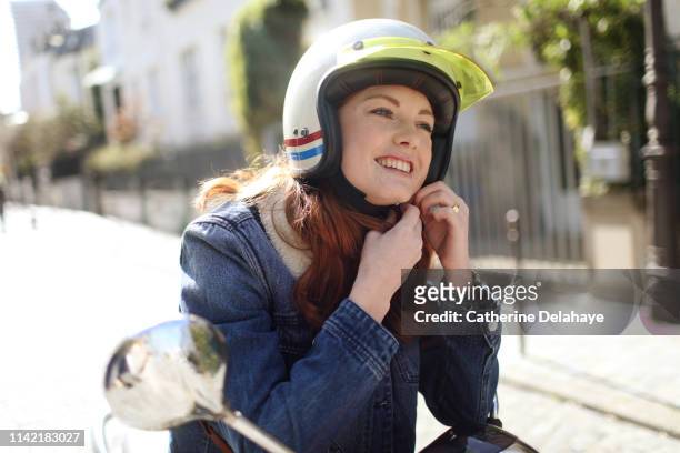portrait of a young woman wearing a helmet in paris - motorradhelm stock-fotos und bilder
