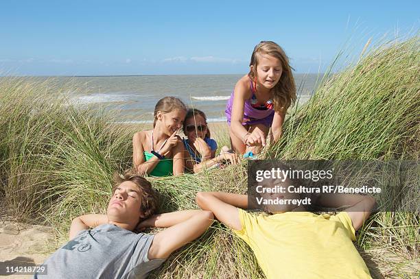 girls teasing boys in sand dune - junge 13 jahre oberkörper strand stock-fotos und bilder