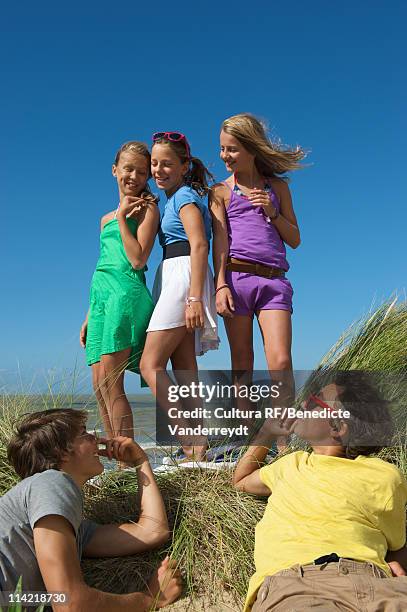 girls charming boys by the sea - junge 13 jahre oberkörper strand stock-fotos und bilder