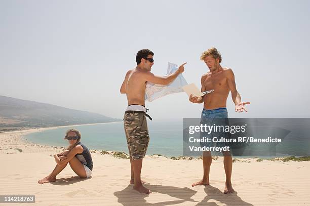 men arguing about paper map versus gps - pechos de mujer playa fotografías e imágenes de stock