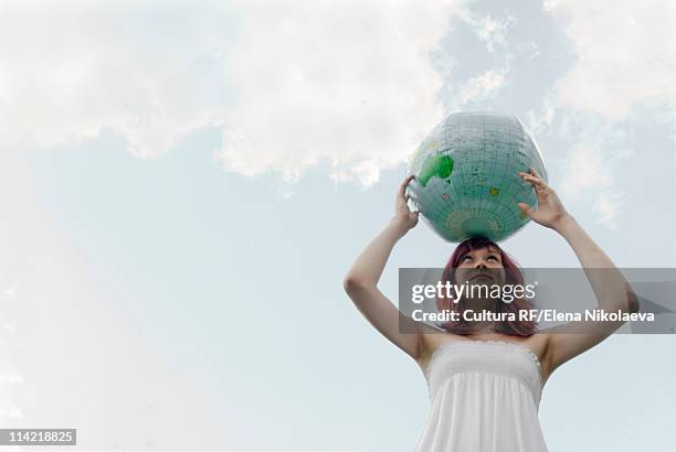 young woman with globe - international day one stock pictures, royalty-free photos & images