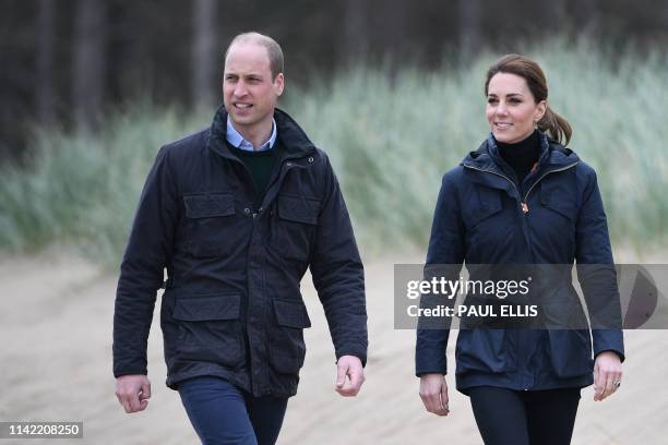 Britain's Prince William, Duke of Cambridge and his wife Britain's Catherine, Duchess of Cambridge walk along Newborough Beach on Anglesey, north...