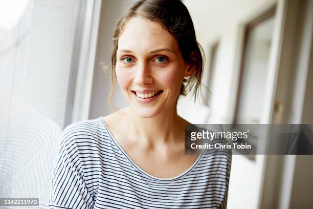 portrait of young woman looking into the camera - natural face stock-fotos und bilder