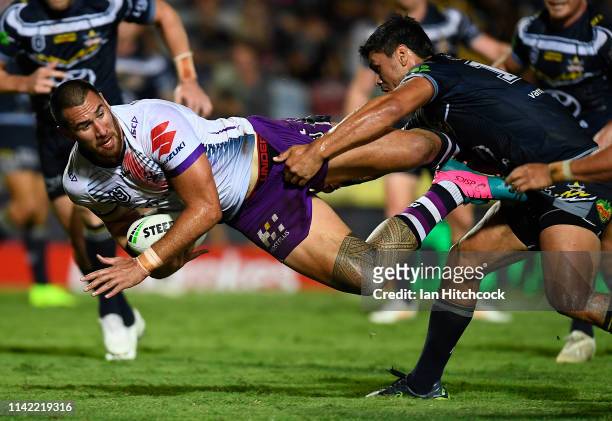 Nelson Asofa-Solomona of the Storm is tackled by Jordan McLean of the Cowboys during the round five NRL match between the North Queensland Cowboys...