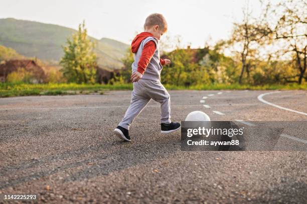 ragazzino che gioca a calcio - baby football foto e immagini stock