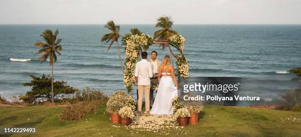 pastor celebrating elopement wedding on the tropical beach - pastor stock pictures, royalty-free photos & images