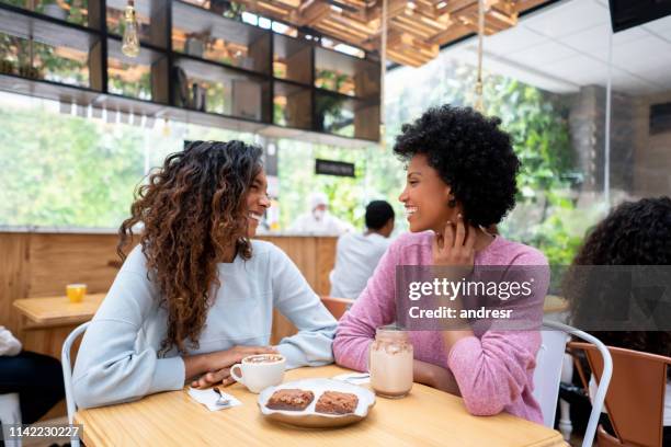 happy afro-amerikaanse vrienden met een kopje koffie in een cafe - brownie stockfoto's en -beelden