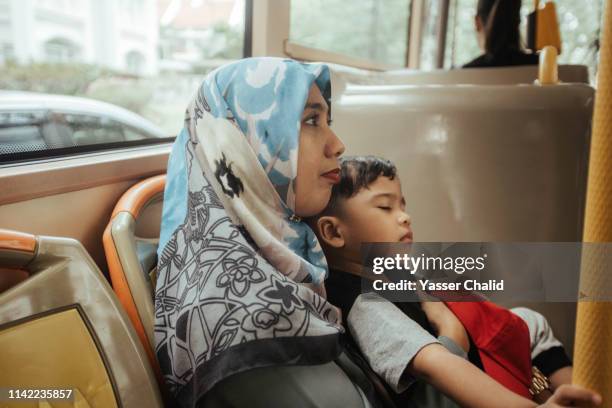 mother and toddler son in a bus - kids sitting together in bus stock-fotos und bilder