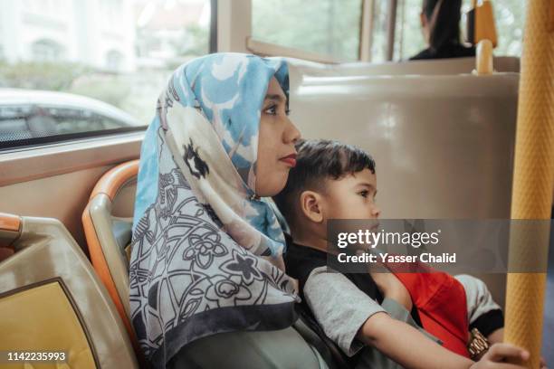 mother and toddler son in a bus - kids sitting together in bus stock pictures, royalty-free photos & images