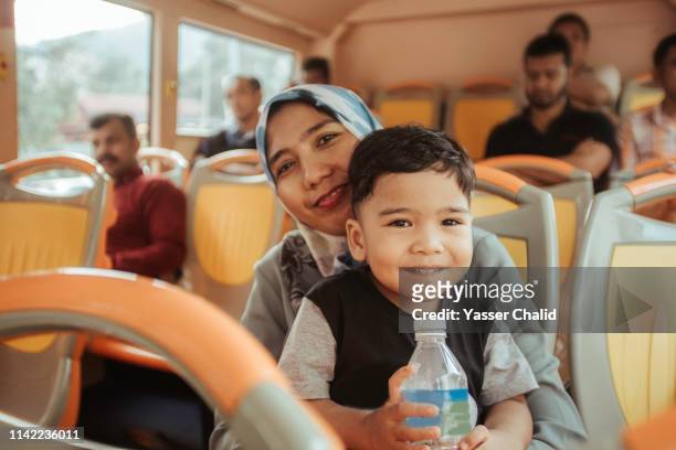 mother and toddler son in a bus - kids sitting together in bus stock-fotos und bilder