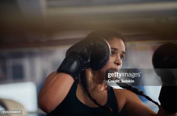 teenage girl exercising in boxing ring - boxing womens stock-fotos und bilder