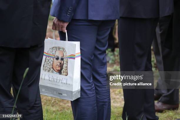 May 2019, Saxony-Anhalt, Wörlitz: The British heir to the throne Prince Charles holds a paper bag with the portrait of the composer Händel in his...