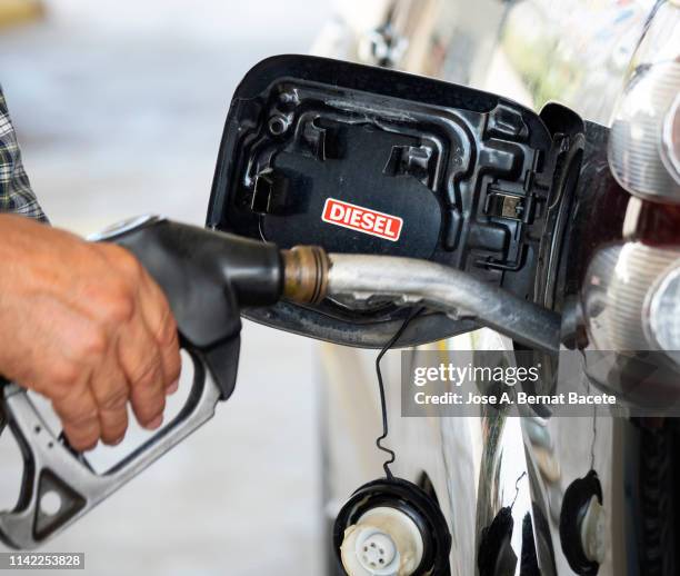 hand of a men from with a hose of fuel refueling a diesel vehicle with self serve pump and hose. spain. - diesel auto stock pictures, royalty-free photos & images