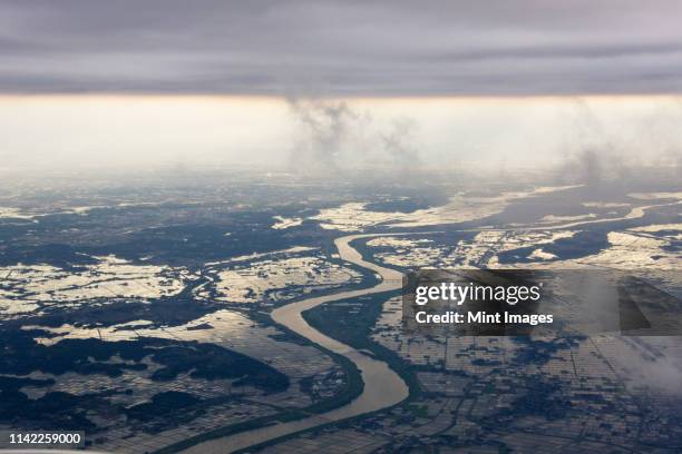 river running through a flooded countryside - 災害 ストックフォトと画像