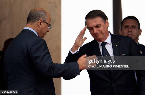 Brazilian President Jair Bolsonaro salutes Rio de Janeiro's Governor Wilson Witzel during a ceremony to commemorate the participation of Brazil in...