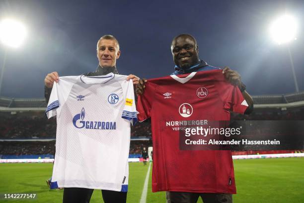 Former FC Nuernberg Marek Mintal and Former FC Shalke 04 player Gerald Asamoah exchange team jerseys prior to the Bundesliga match between 1. FC...