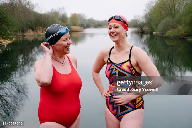 two female wild swimmers laughing by a lake - real life stock pictures, royalty-free photos & images