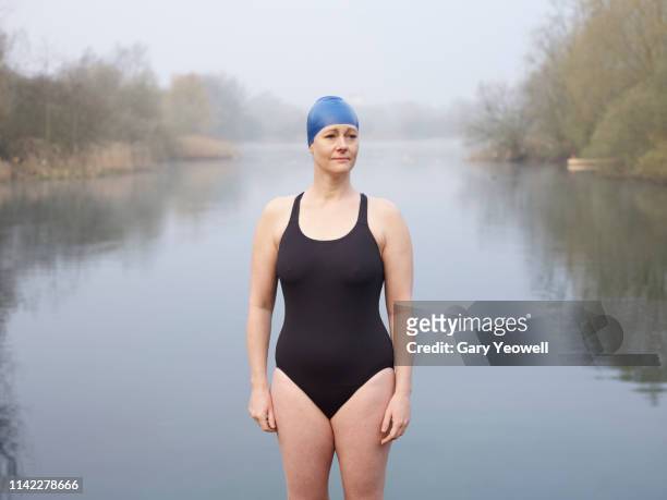 female wild swimmer standing by a lake - outdoor swimming stock pictures, royalty-free photos & images