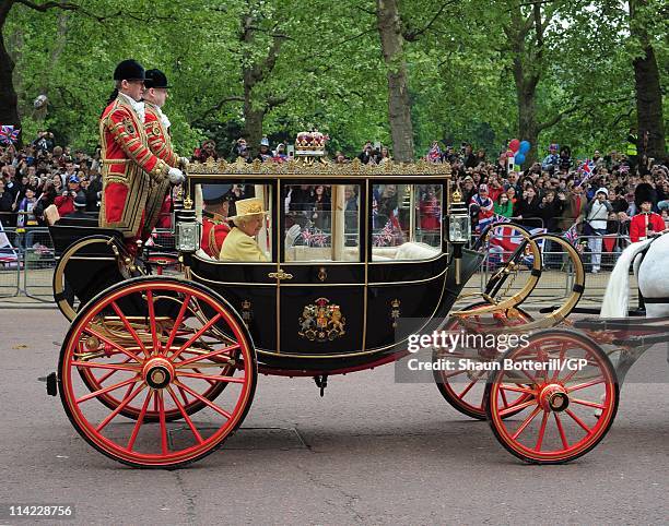 Queen Elizabeth II and Prince Philip, Duke of Edinburgh ride in a carriage procession to Buckingham Palace following the marriage of Their Royal...