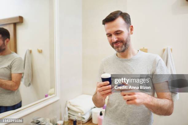 man applying deodorant to his armpits. debica, poland - roll on bildbanksfoton och bilder