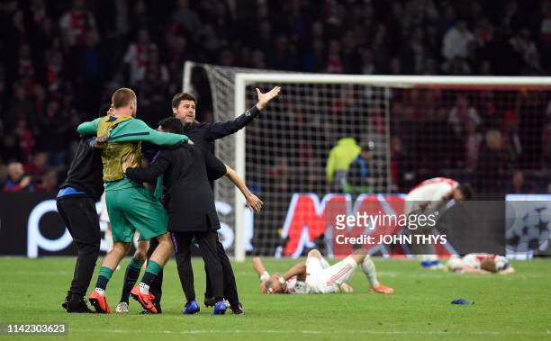 Tottenham's Argentine coach Mauricio Pochettino celebrates next to Ajax players reacting on the ground, after Tottenham won the UEFA Champions League...