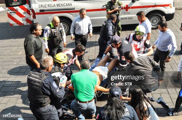 An injured man receives first aid after a gunman opened fire in the central square of Cuernavaca, Morelos state, in Mexico on May 8, 2019. - Two...