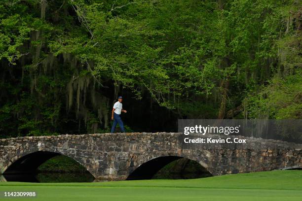 Tiger Woods of the United States walks across the Nelson bridge on the 13th hole during the second round of the Masters at Augusta National Golf Club...