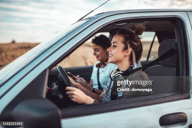 zwillingsschwester, die an einem sonnigen sommertag einen roadtrip hat - young child car driving stock-fotos und bilder