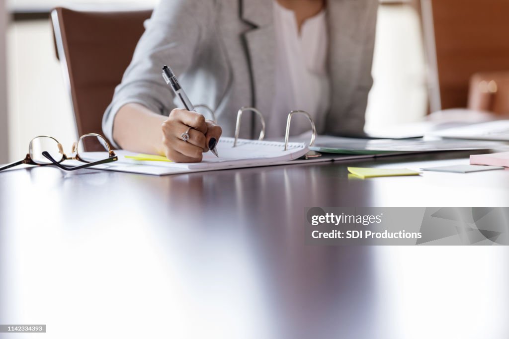 Unrecognizable businesswoman works at table
