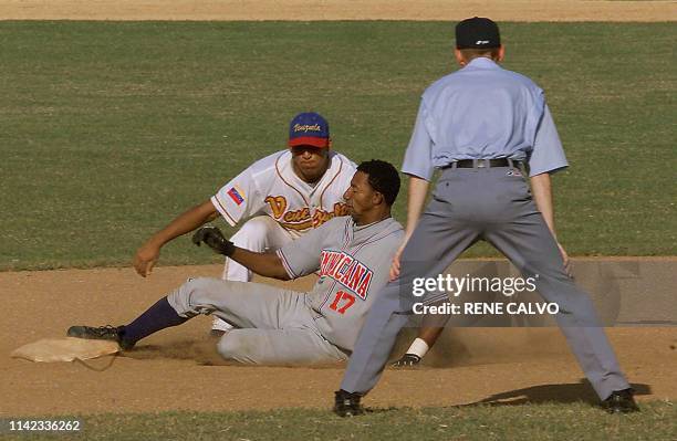 Napoleon Calzado , of the Dominican Republic, slides on second base, which is being guarded by Rainer Laya, of the Venezuelan team, during a game of...