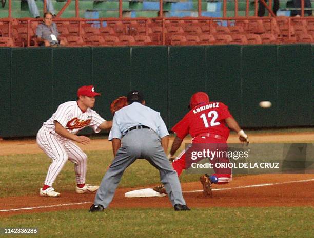 Michel Enriquez , who plays third base for the Cuban team, slides on third base and scores a triple, observed by the third base judge , while Ren...