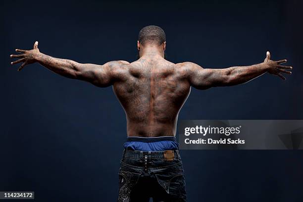 man with tattoos, arms spread, back view - arm tattoos for black men fotografías e imágenes de stock