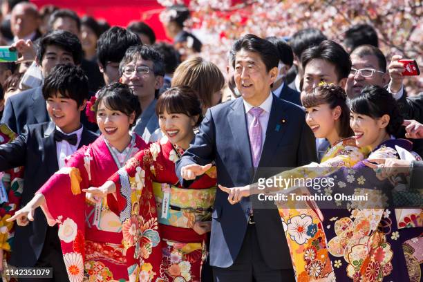 Japan's Prime Minister Shinzo Abe poses with members of idol unit Momoiro Clover Z during the cherry blossom viewing party at the Shinjuku Gyoen...