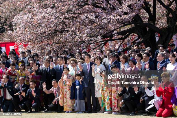 Japan's Prime Minister Shinzo Abe and his wife Akie pose for photographs with guest attendees during the cherry blossom viewing party at the Shinjuku...