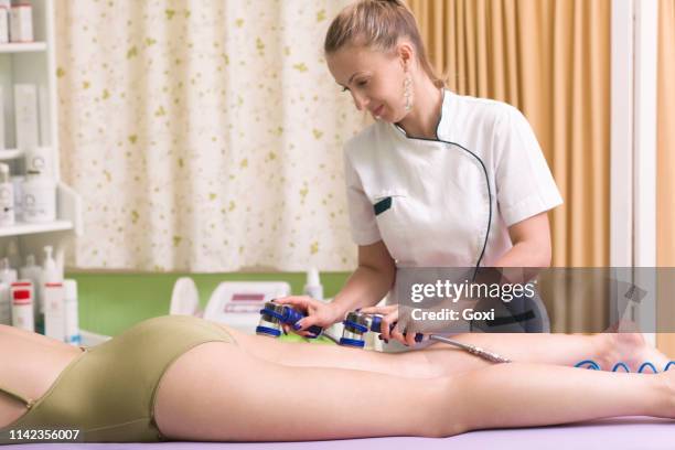 woman receiving cellulite vacuum therapy - lymphatic system stock pictures, royalty-free photos & images