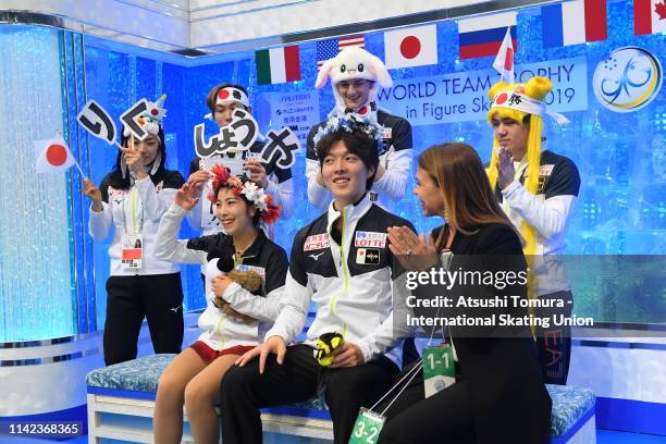 RikuÂ Miura and ShoyaÂ Ichihashi of Japan wait for their score at the kiss and cry with their team mates after competing in the Pair Free Skating on...