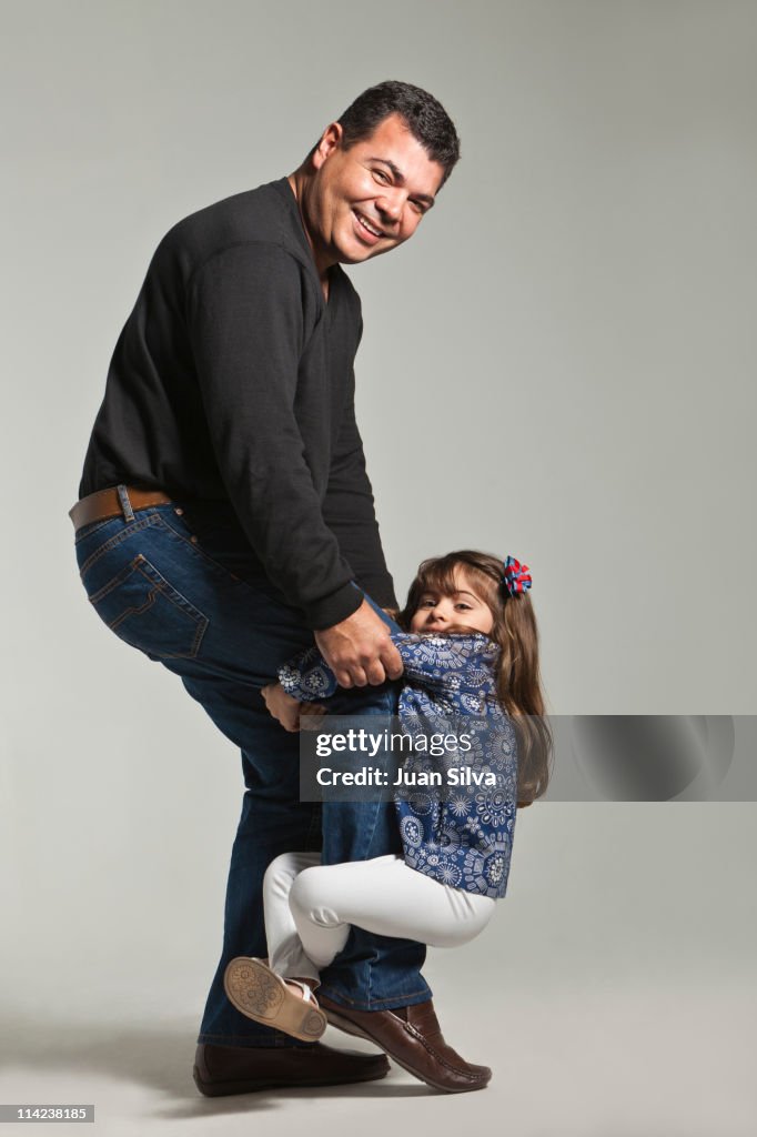 Father with daughter hanging on leg