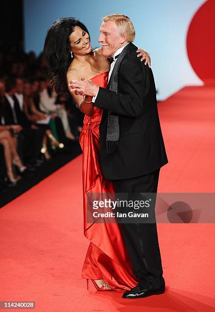 Presenter Bruce Forsyth and his wife Wilnelia walk the runway at Fashion For Relief at Forville market during the 64th Annual Cannes Film Festival on...