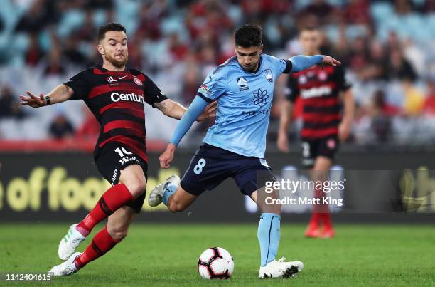 Paulo Retre of Sydney FC is challenged by Alexander Baumjohann of the Wanderers during the round 25 A-League match between the Western Sydney...