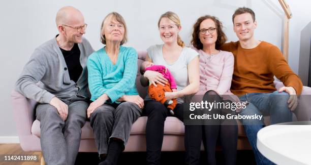 Bonn, Germany In this photo illustration a Mother, Father, Grandmother, Grandfather and a great-grandmother and a baby sitting on a sofa on March 15,...