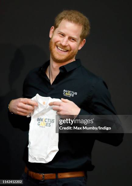 Prince Harry, Duke of Sussex is presented with an Invictus Games baby grow for his newborn son Archie as he visits Sportcampus Zuiderpark as part of...