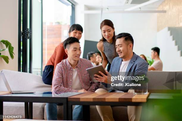 junge mannschaft in einem modernen co-working office - asiatische kultur stock-fotos und bilder